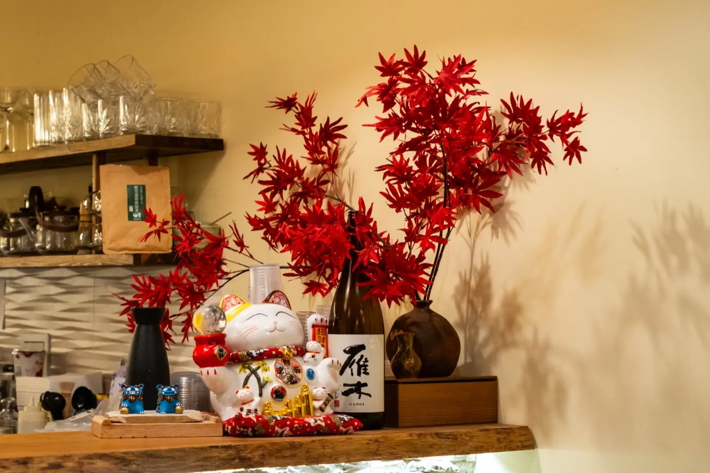 Zátiší s javorem, kočkou maneki-neko a lahví sake